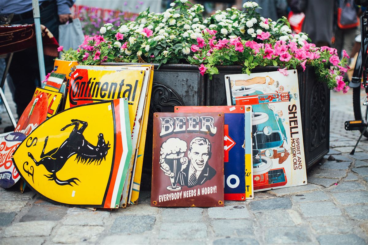 Bunte Emaille-Schilder auf einem Flohmarktstand